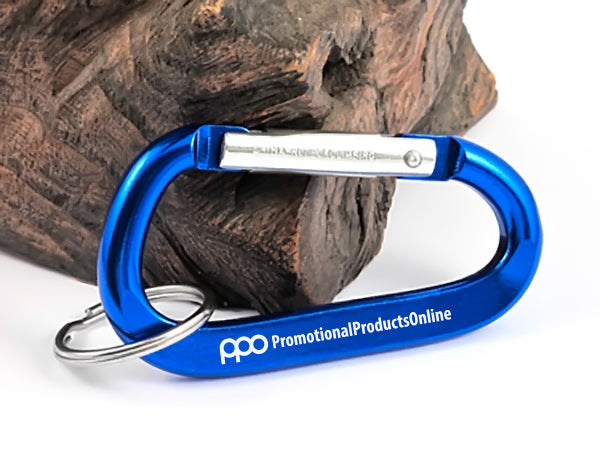 A closeup image of a 70mm royal blue carabiner with ring and a sample engraving, on a white background.