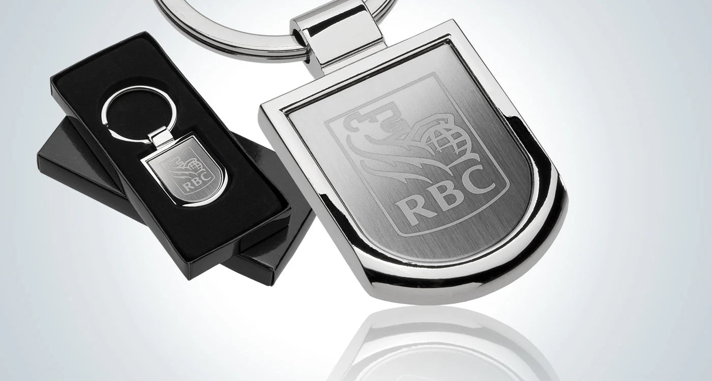 Metallic keychain with RBC logo on a reflective surface